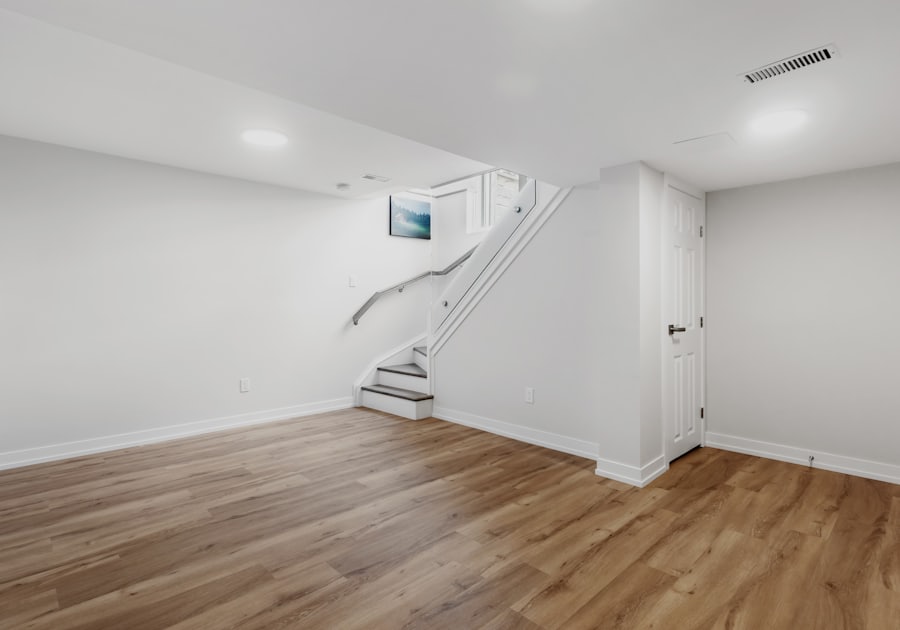 Finished basement room with hardwood floors and staircase